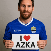 a man in a blue sportana jersey holds up a sign that says i love azka
