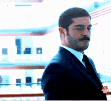a man in a suit and tie is standing in front of a building