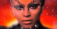 a close up of a woman 's face with a lot of makeup on .
