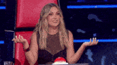 a woman sitting in a red chair with her hands out