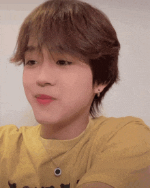 a young boy wearing a yellow t-shirt and a necklace