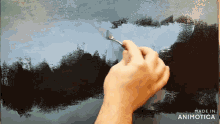 a hand holding a brush on a canvas that says made in animotica on the bottom