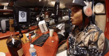 a man wearing headphones is singing into a microphone in front of a box that says beats