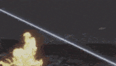 a robot is shooting a laser at another robot with a flame coming out of it .