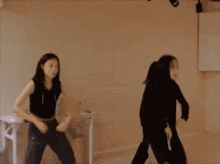 a couple of girls are dancing in a room .