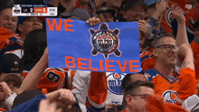 a fan holding a sign that says we believe