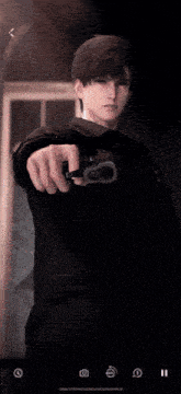 a man in a suit is holding a gun in his hand .