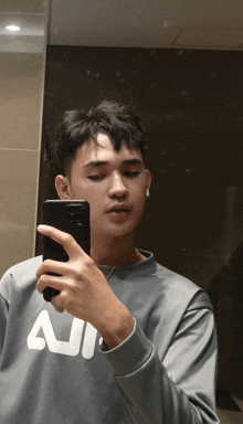 a man taking a picture of himself in a mirror wearing a sweater that says all