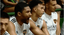 a group of basketball players wearing qatar airways shirts