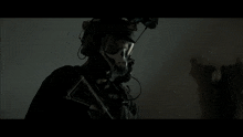 a man in a military uniform is standing in the dark holding a gun