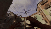 a helicopter is flying over a city with a person reaching out towards it