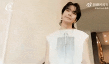 a man wearing a white tank top and a necklace is smiling .