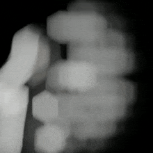a black and white photo of a person 's hand holding something in a dark room .