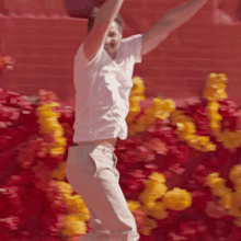 a man in a white shirt and khaki pants is jumping in the air