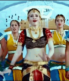 a woman in a costume is dancing with a group of women .