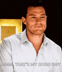 a man in a white shirt is talking to someone and says `` mmmm , that 's my good boy '' .