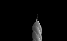 a candle is lit with a match in a black and white photo
