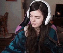 a woman wearing headphones is sitting in a chair with a microphone