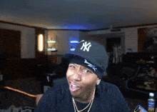 a man wearing a new york yankees hat is making a face