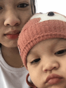 a little girl wearing a knitted hat with a bear on it