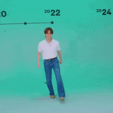 a young man wearing a white shirt and blue jeans is dancing .