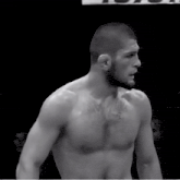 a black and white photo of a shirtless fighter with a toyota sign behind him