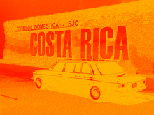 a car is parked in front of a sign for costa rica