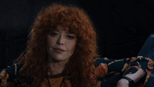 a woman with red hair is sitting in front of a black background that says bull shit