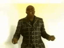 a man in a leather jacket is dancing in front of a yellow background .