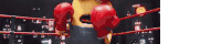 a minion wearing red boxing gloves is in a boxing ring