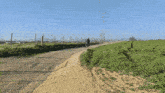 a man is riding a dirt bike down a dirt road