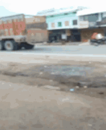 a truck is driving down a road in front of a building