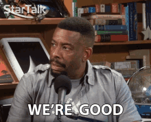 a man says we 're good in front of a bookshelf full of books