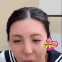 a close up of a woman 's face with a heart sticker on her face .