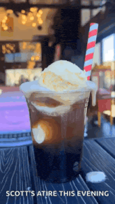 a cup of iced coffee with a scoop of vanilla ice cream and a striped straw .