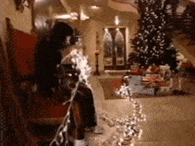 a man is sitting in a chair with a christmas tree in the background