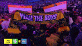 a man holding a scarf that says " yeah the boys "