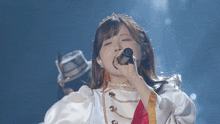 a woman singing into a microphone with a tiara on her head