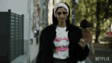 a woman wearing a fur coat and a t-shirt that says 50
