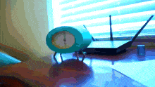 a blue clock sits next to a router on a table