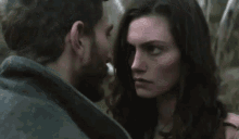 a man and a woman are looking at each other with a serious look on their faces
