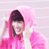 a person wearing a pink hoodie is smiling