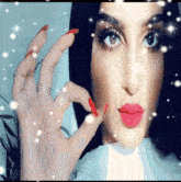 a close up of a woman 's face with red nails and pink lips