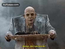 a bald man in a suit is holding a tray of food and says `` but but ... don 't you love me ? ''