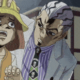a man in a suit and tie with skulls on it stands next to a girl in a yellow hat
