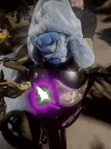 a stuffed animal is sitting on the front of a honda motorbike