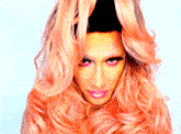 a drag queen with long pink hair and pink makeup