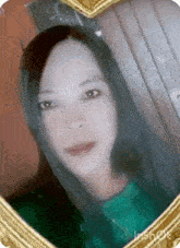 a woman is taking a selfie in a heart shaped picture frame .