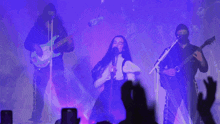 a woman is singing into a microphone while a man plays a guitar