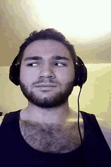 a man with a beard is wearing headphones and making a funny face
